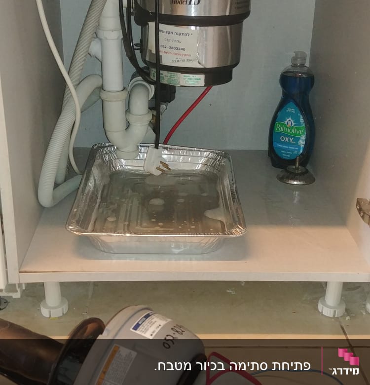 כלי עבודה של אינסטלטור מתחת לכיור מטבח